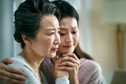 Daughter gently embracing her grieving mother, offering comfort and emotional support in a moment of sorrow.